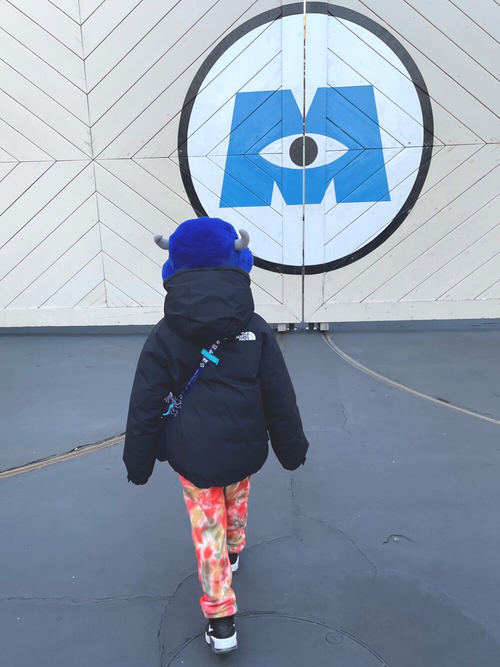 オレンジ系のスウェットパンツ、ブラック系のスニーカー、ブラック系のダウンジャケット/コートを着用したキッズの冬コーディネートの2枚目の写真