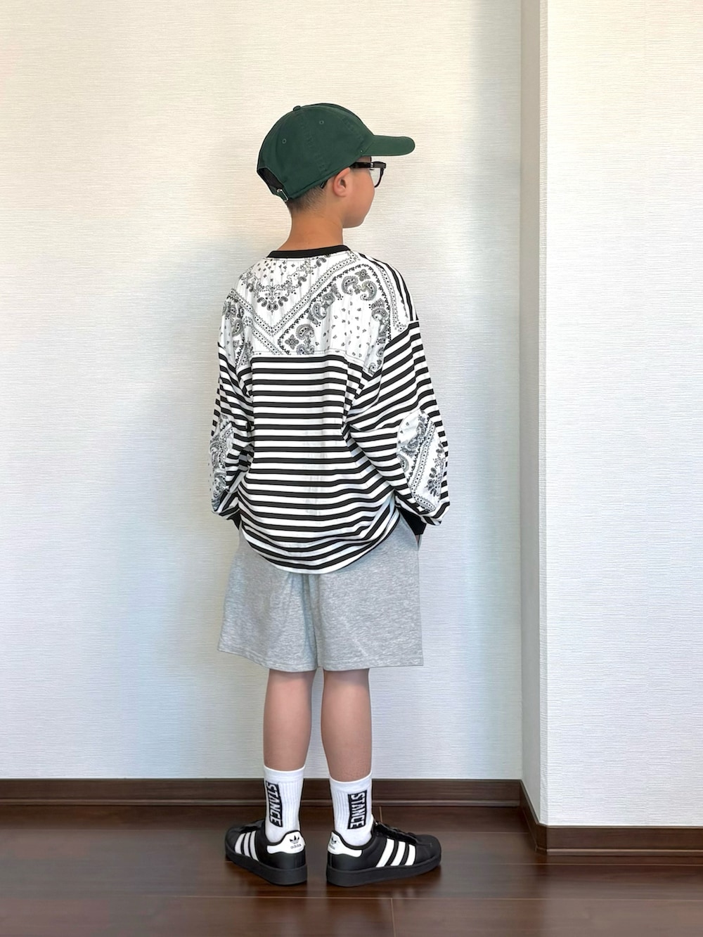 ブラック系のTシャツ/カットソー、ブラック系のスニーカー、グレー系のその他パンツを着用したキッズの春コーディネートの2枚目の写真