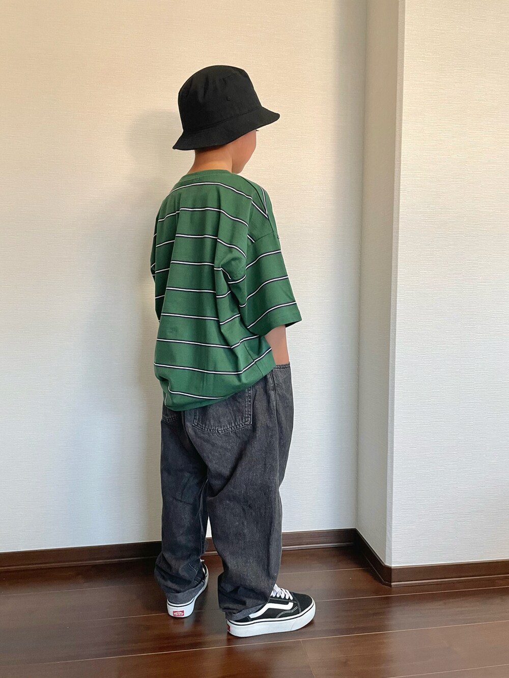 グリーン系のTシャツ/カットソー、ブラック系のデニムパンツ、ブラック系のスニーカーを着用したキッズの秋コーディネートの2枚目の写真