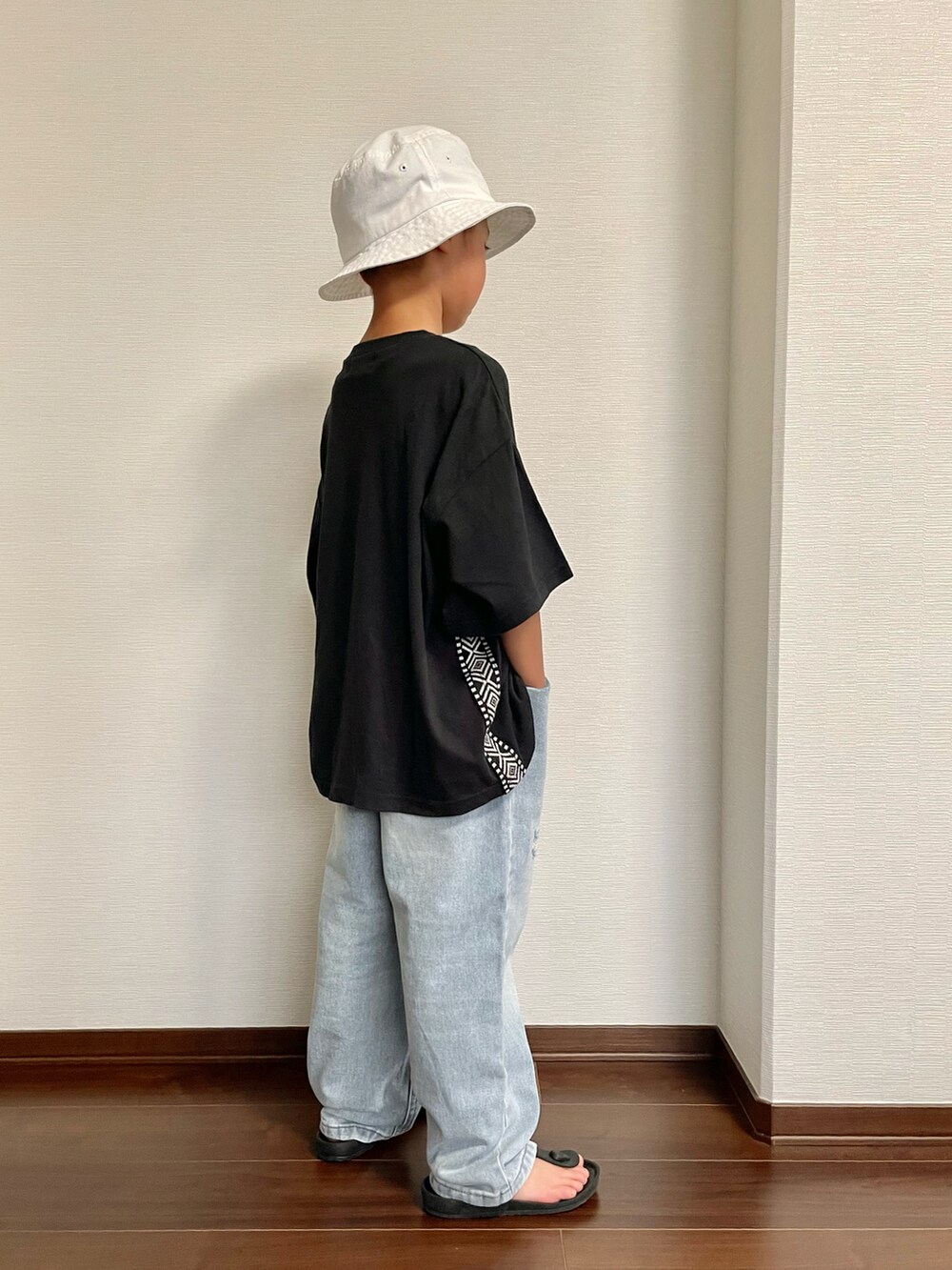 ブラック系のサンダル、ブラック系のTシャツ/カットソー、ブルー系のデニムパンツを着用したキッズの夏コーディネートの2枚目の写真
