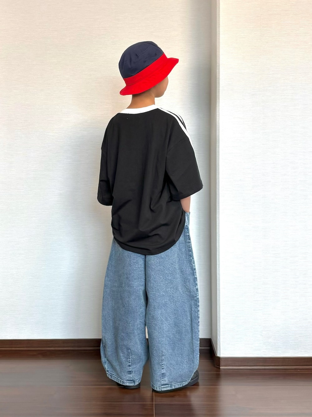 ブラック系のスニーカー、ブラック系のTシャツ/カットソー、ブルー系のデニムパンツを着用したキッズの夏コーディネートの3枚目の写真