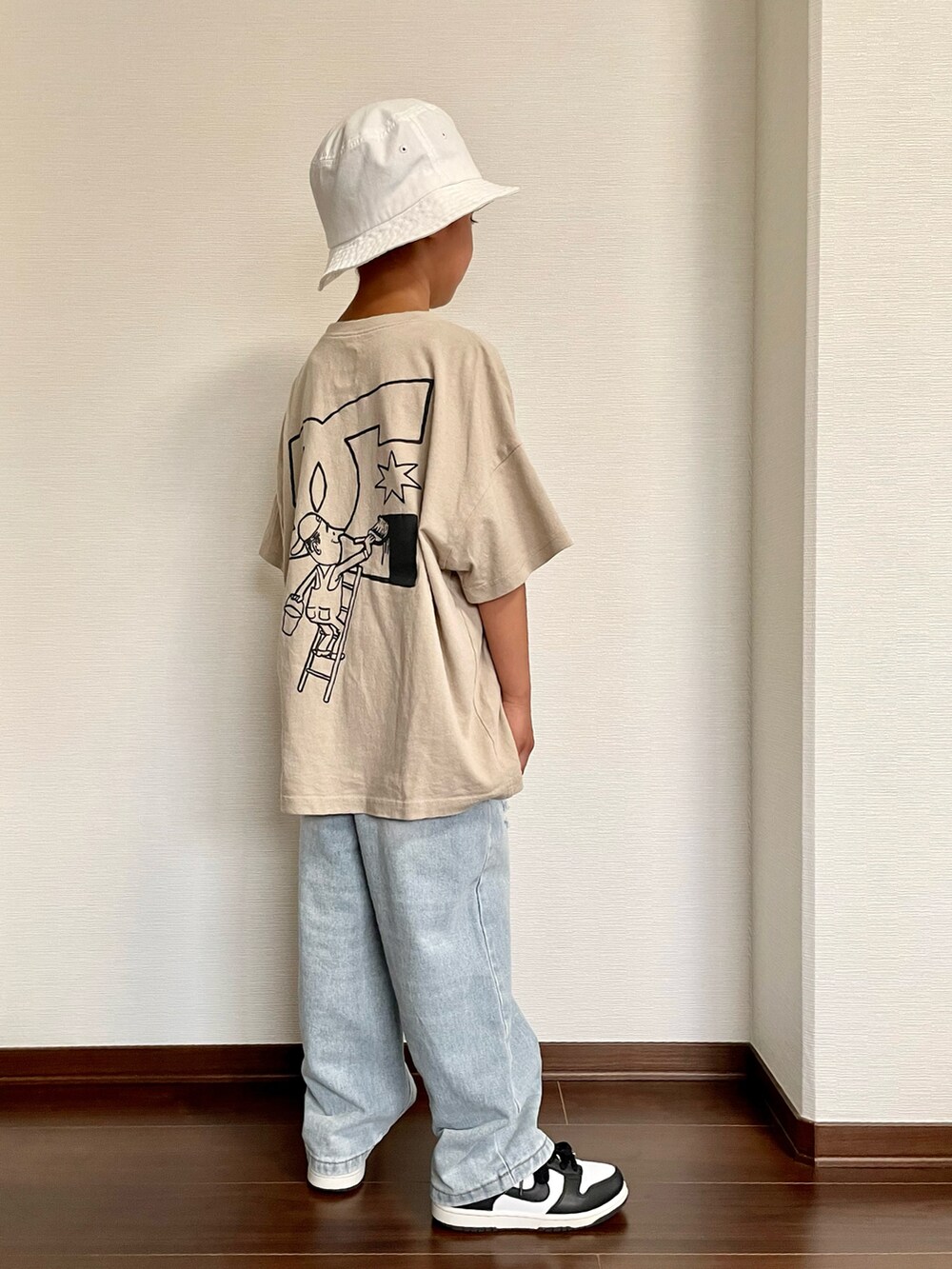 ベージュ系のTシャツ/カットソー、ブルー系のデニムパンツ、ブラック系のスニーカーを着用したキッズの夏コーディネートの2枚目の写真