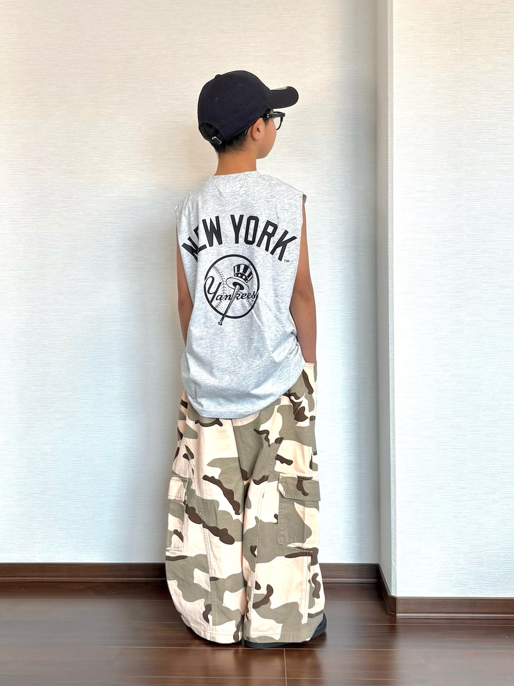 グリーン系のカーゴパンツ、ブラック系のスニーカー、グレー系のタンクトップを着用したキッズの夏コーディネートの4枚目の写真