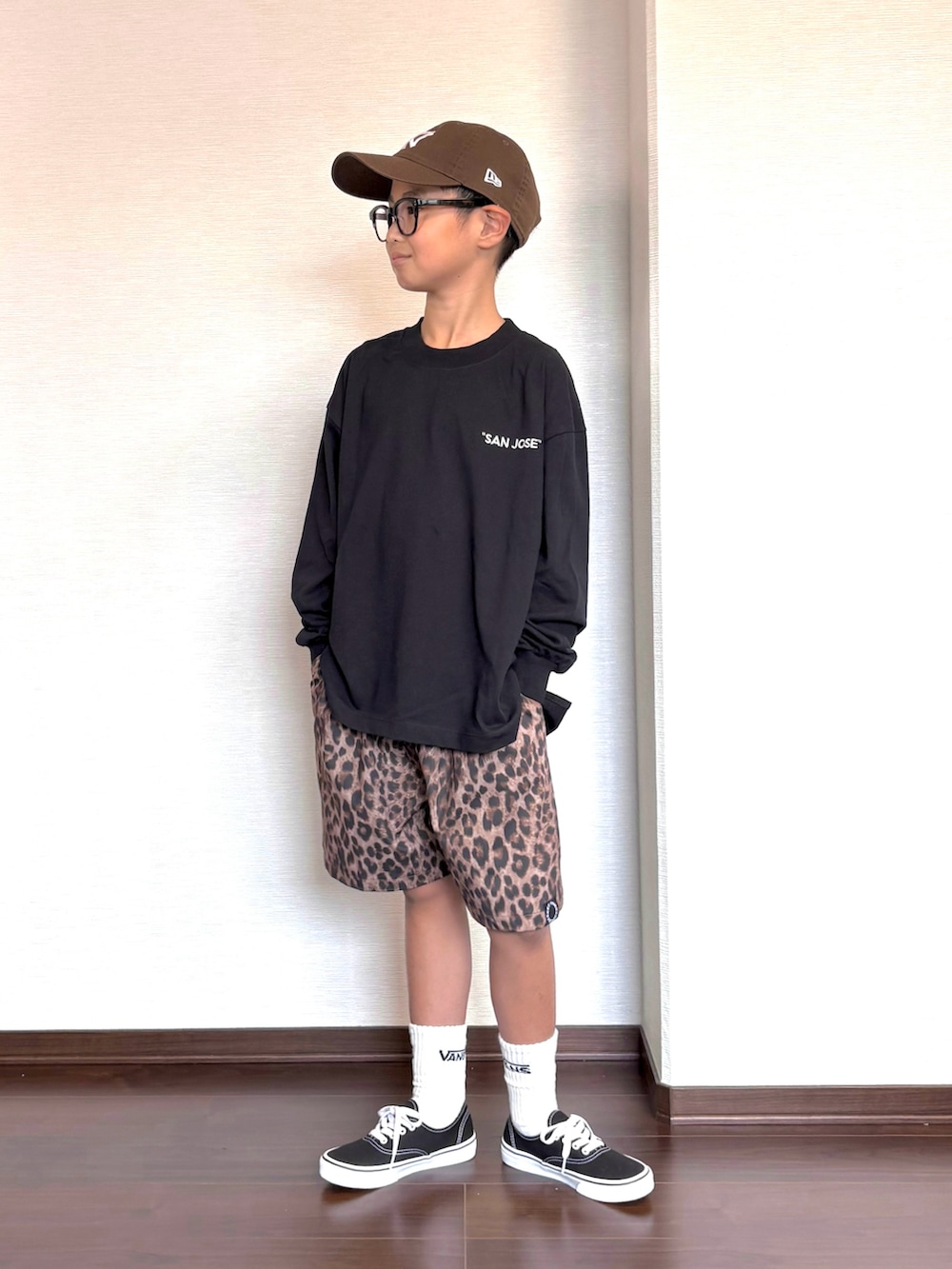ブラック系のTシャツ/カットソー、ベージュ系のその他パンツ、ブラック系のスニーカーを着用したキッズの秋コーディネートの2枚目の写真
