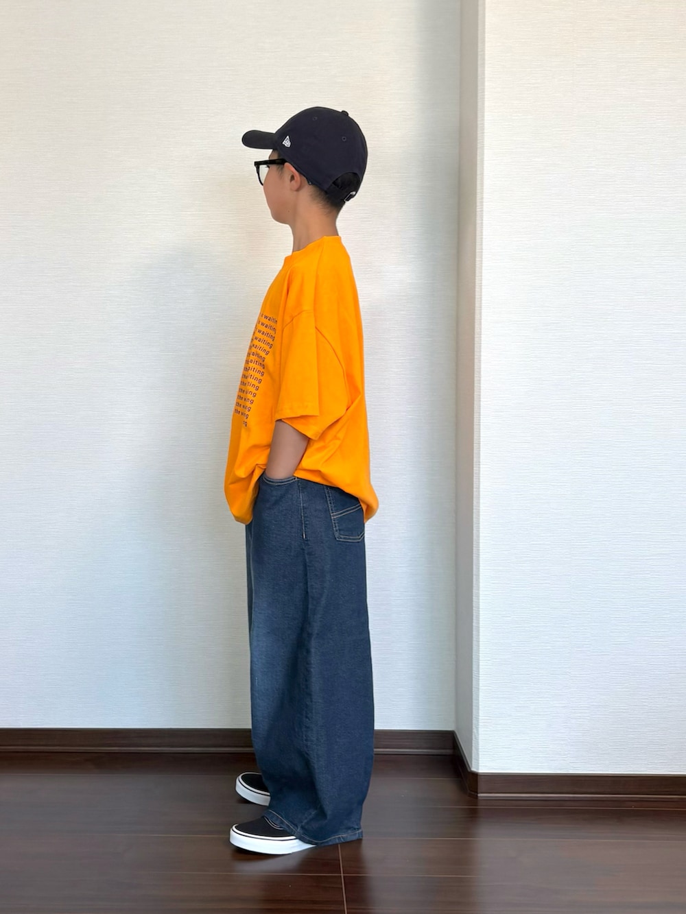 オレンジ系のTシャツ/カットソー、ブルー系のデニムパンツ、ブラック系のスニーカーを着用したキッズの夏コーディネートの3枚目の写真