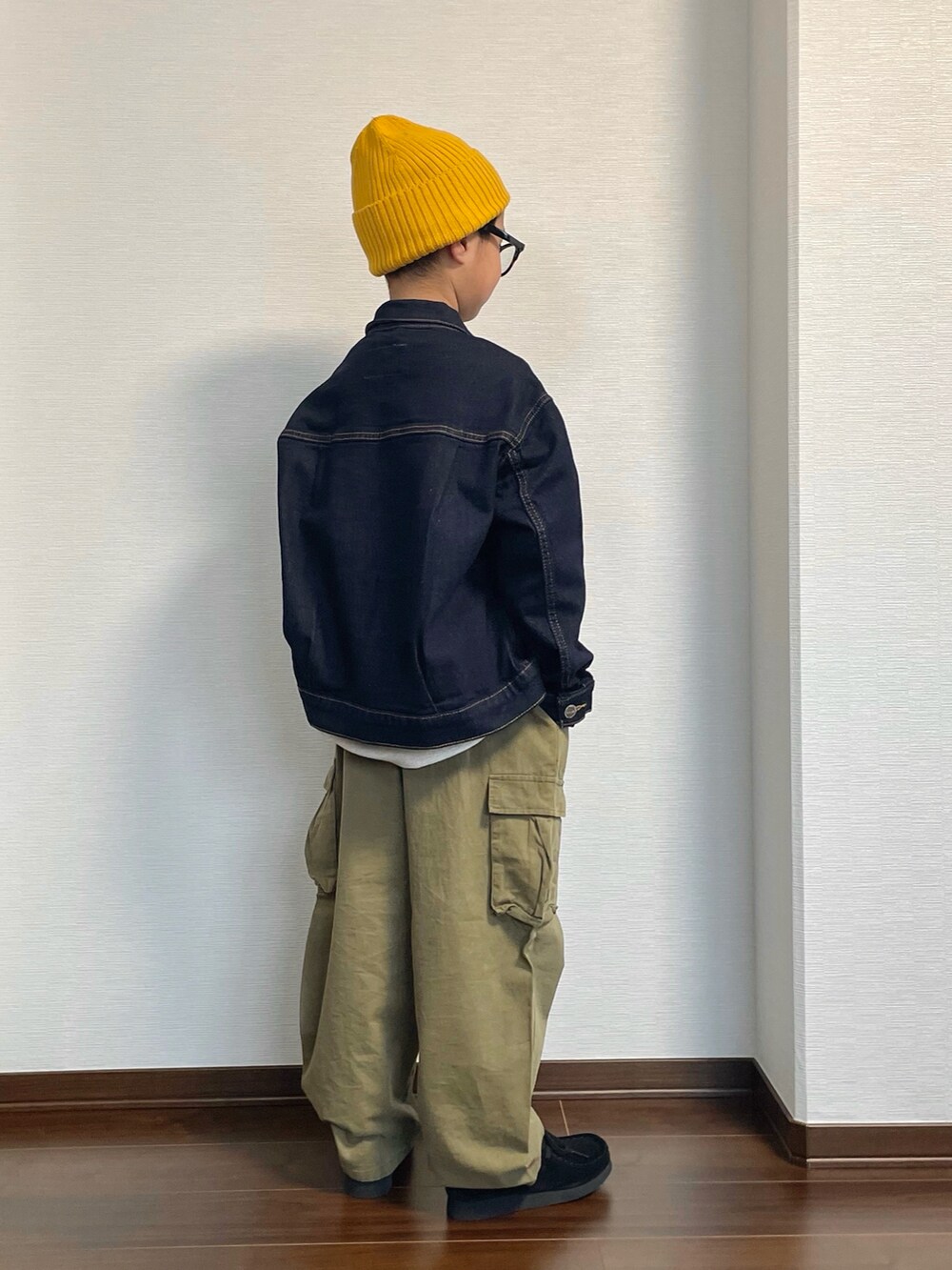 ブルー系のデニムジャケット、ベージュ系のスウェット、グリーン系のカーゴパンツを着用したキッズの冬コーディネートの2枚目の写真