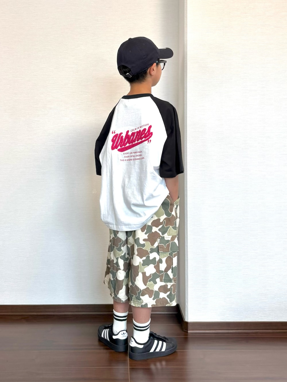 ブラック系のスニーカー、ホワイト系のTシャツ/カットソー、ベージュ系のカーゴパンツを着用したキッズの夏コーディネートの2枚目の写真