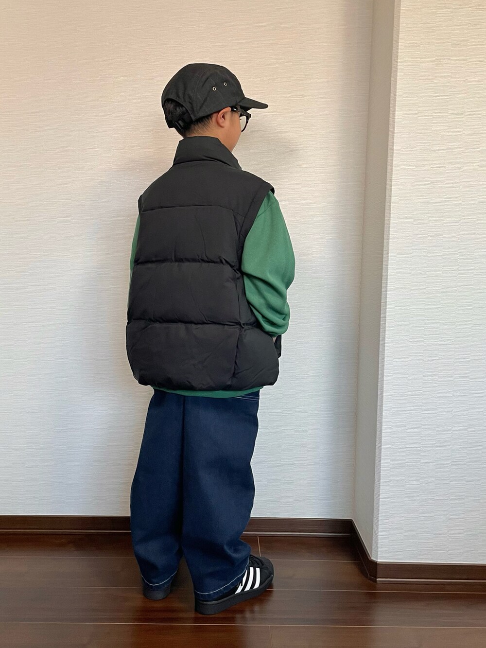 ブラック系のジャケット/アウター、グリーン系のスウェット、ブルー系のデニムパンツを着用したキッズの秋コーディネートの2枚目の写真