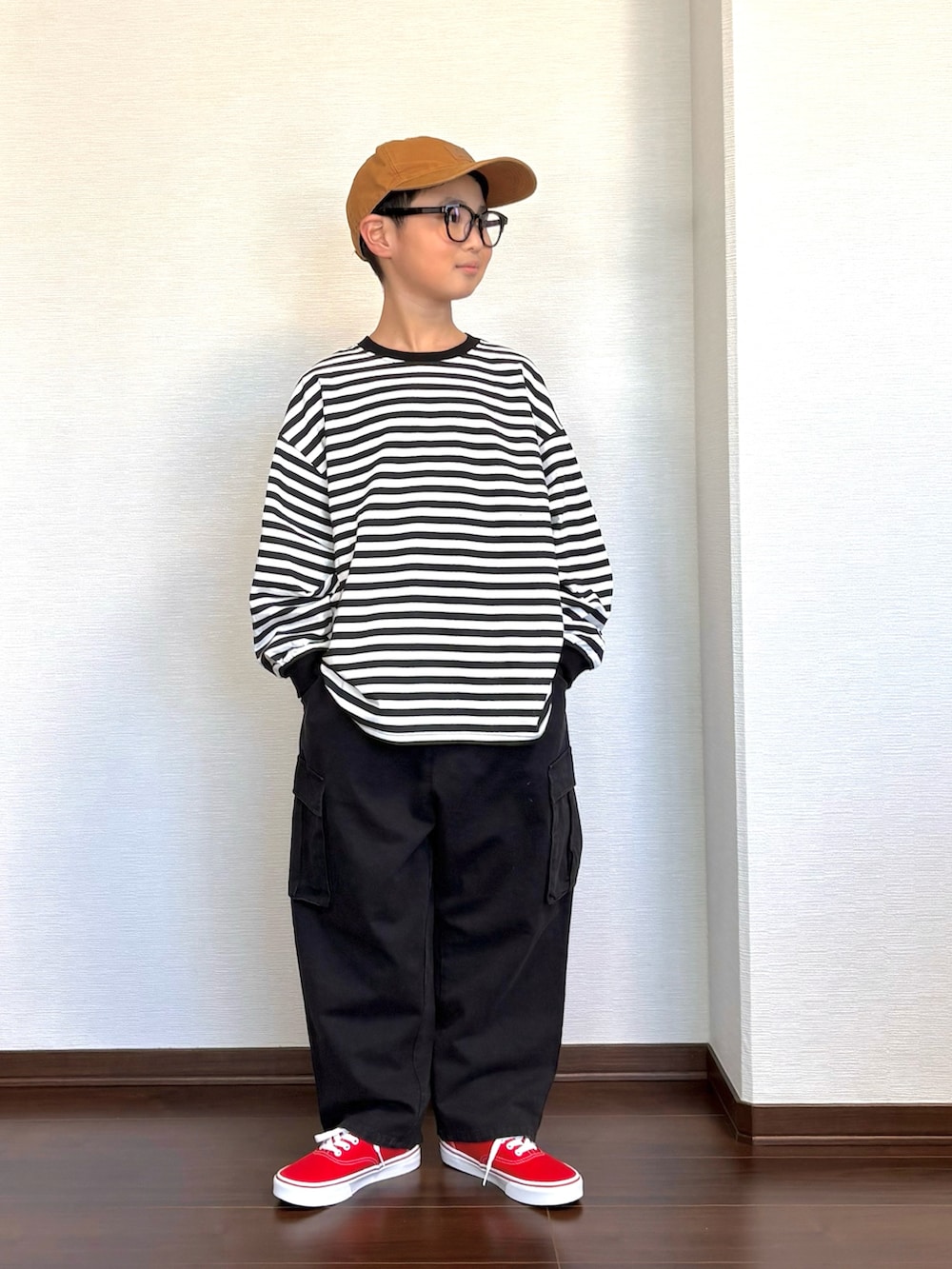 ブラック系のカーゴパンツ、ブラック系のTシャツ/カットソー、レッド系のスニーカーを着用したキッズの春コーディネートの3枚目の写真