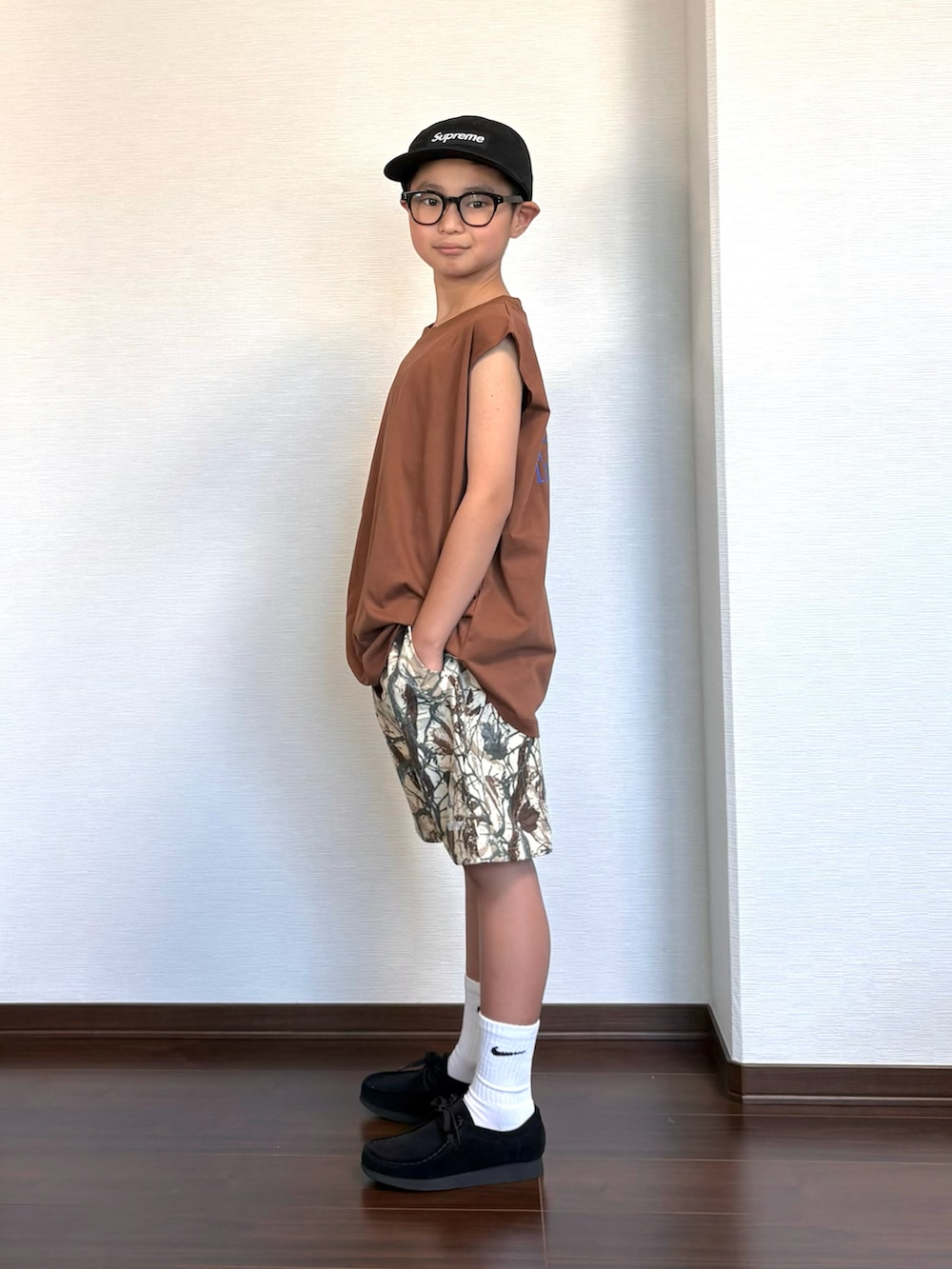 ブラウン系のタンクトップ、ベージュ系のパンツ、ブラック系のシューズを着用したキッズの夏コーディネートの3枚目の写真