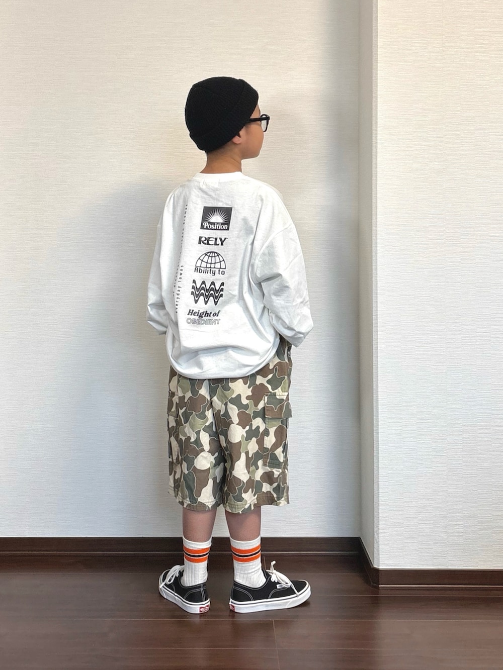 ベージュ系のカーゴパンツ、ホワイト系のTシャツ/カットソー、ブラック系のスニーカーを着用したキッズの春コーディネートの2枚目の写真