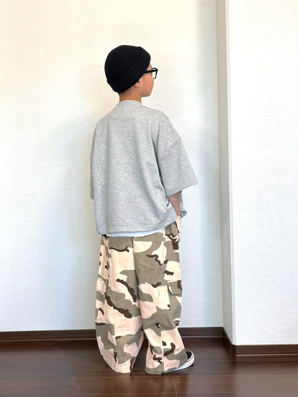 グリーン系のカーゴパンツ、グレー系のセットアップ、ホワイト系のタンクトップを着用したキッズの夏コーディネートの3枚目の写真