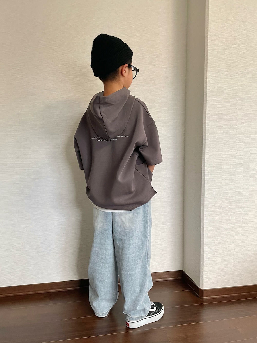 グレー系のパーカー、ホワイト系のタンクトップ、ブルー系のデニムパンツを着用したキッズの夏コーディネートの2枚目の写真