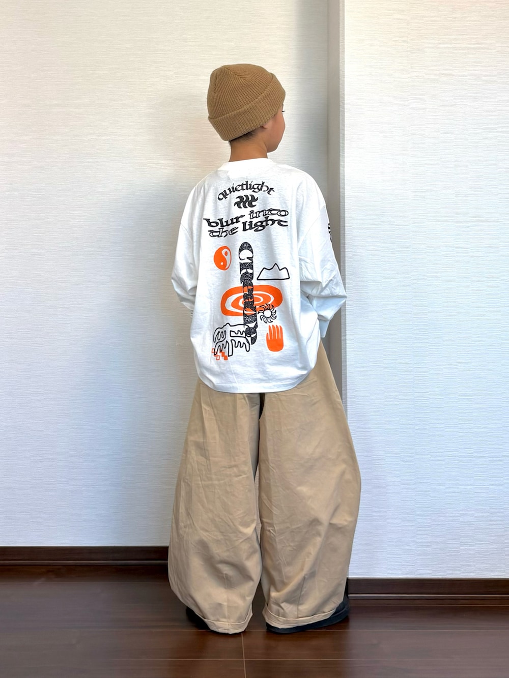ホワイト系のTシャツ/カットソー、ベージュ系のその他パンツ、ブラック系のスニーカーを着用したキッズの秋コーディネートの2枚目の写真