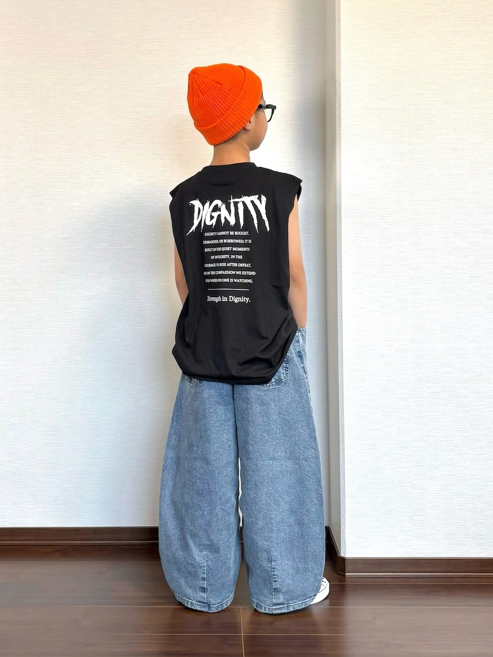 ブラック系のタンクトップ、ブルー系のデニムパンツ、ブラック系のスニーカーを着用したキッズの夏コーディネートの3枚目の写真