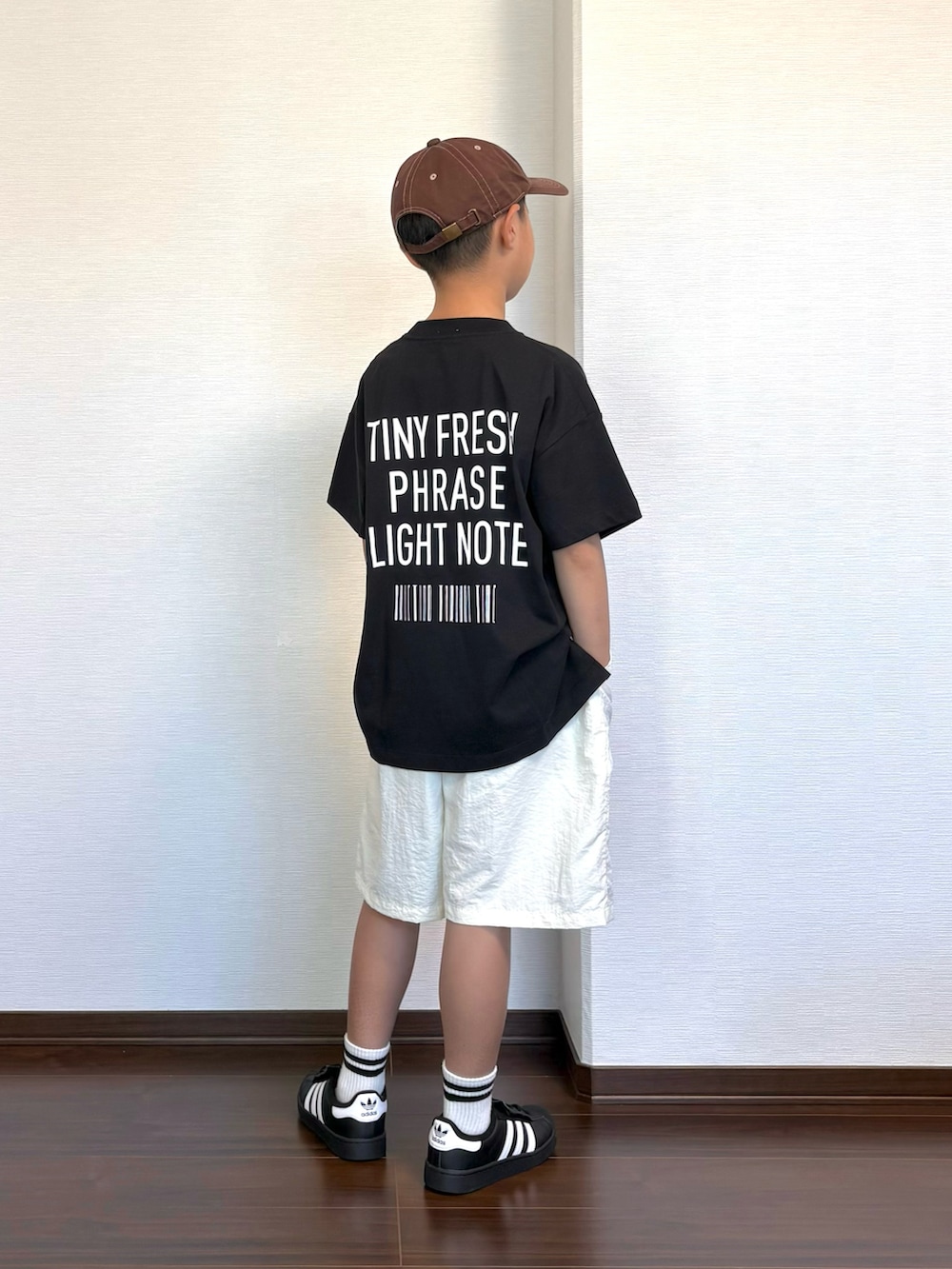 ブラック系のTシャツ/カットソー、ホワイト系のその他パンツ、ブラック系のスニーカーを着用したキッズの夏コーディネートの2枚目の写真