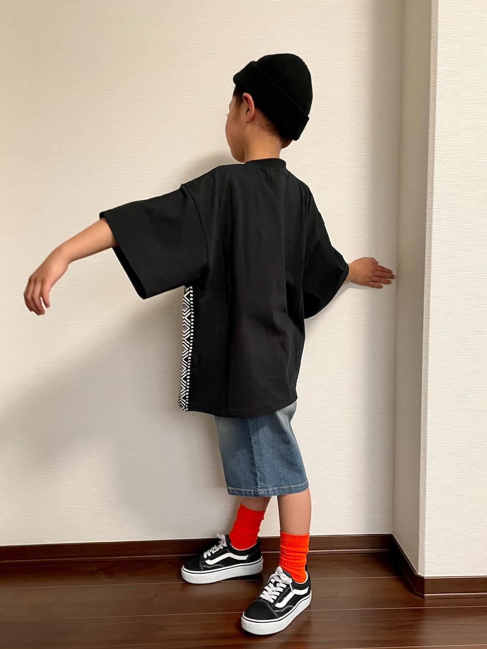 ブラック系のTシャツ/カットソー、ブルー系のデニムパンツ、ブラック系のスニーカーを着用したキッズの春コーディネートの3枚目の写真
