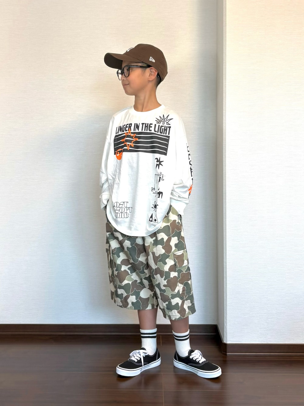 ホワイト系のTシャツ/カットソー、ベージュ系のカーゴパンツ、ブラック系のスニーカーを着用したキッズの秋コーディネートの2枚目の写真