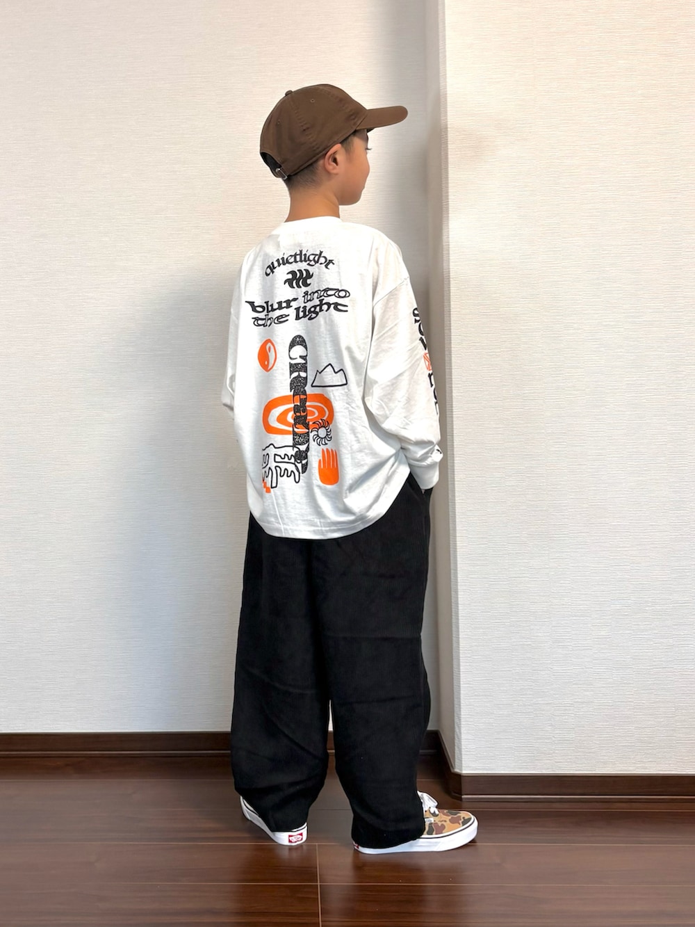 ホワイト系のTシャツ/カットソー、ブラック系のその他パンツ、ブラウン系のスニーカーを着用したキッズの秋コーディネートの2枚目の写真