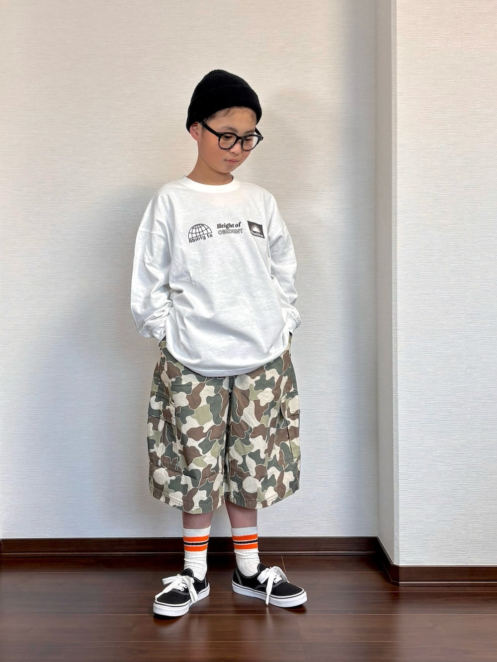 ベージュ系のカーゴパンツ、ホワイト系のTシャツ/カットソー、ブラック系のスニーカーを着用したキッズの春コーディネートの3枚目の写真