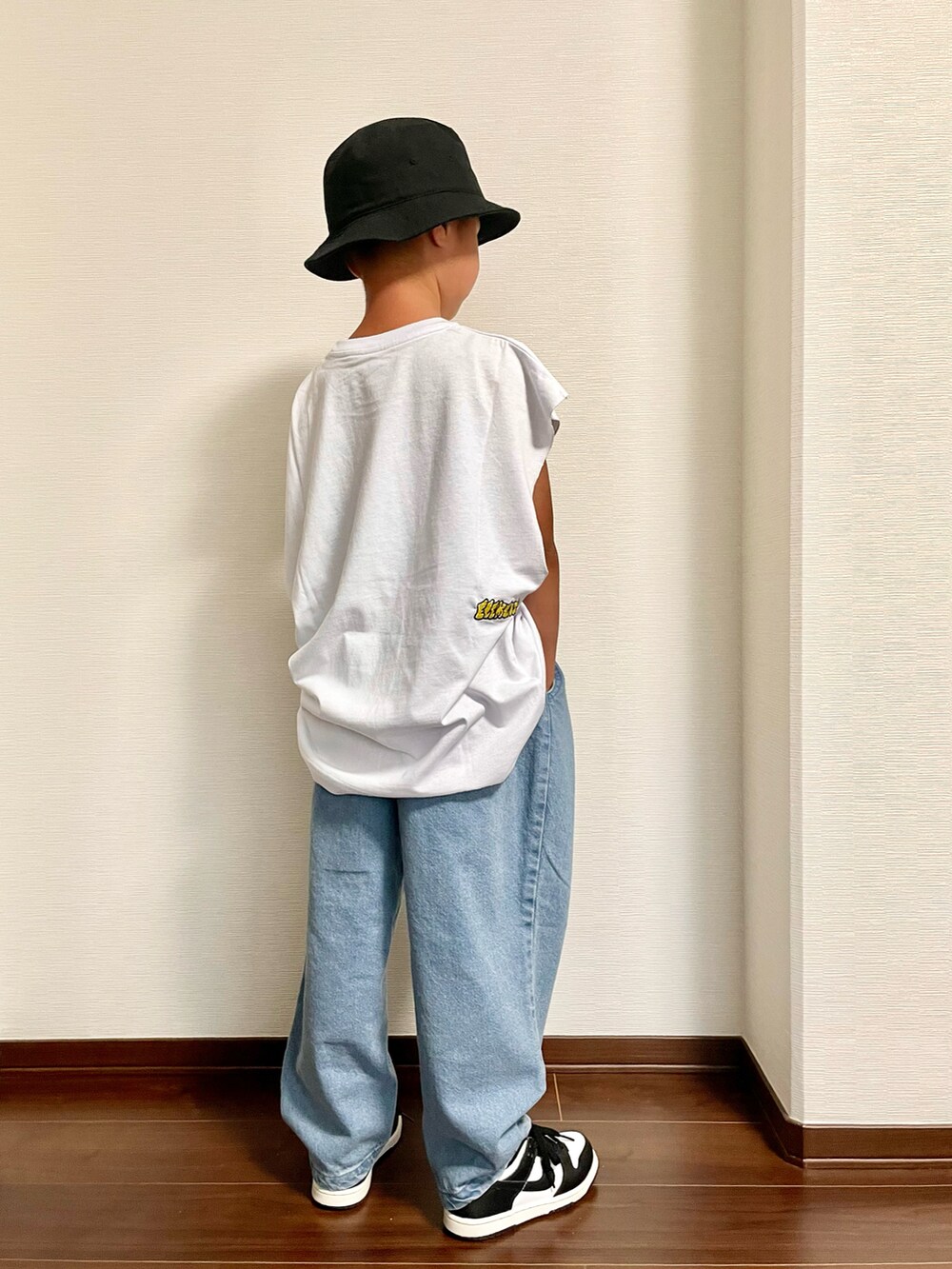 ブルー系のデニムパンツ、ブラック系のスニーカー、ホワイト系のTシャツ/カットソーを着用したキッズの夏コーディネートの2枚目の写真