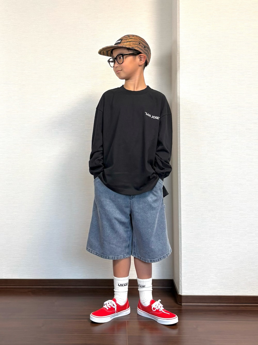 ブラック系のTシャツ/カットソー、ブルー系のその他パンツ、レッド系のスニーカーを着用したキッズの秋コーディネートの2枚目の写真