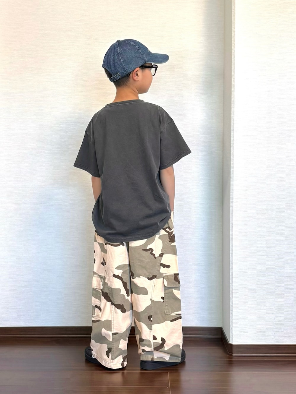 グリーン系のカーゴパンツ、ブラック系のスニーカー、ブラック系のTシャツ/カットソーを着用したキッズの春コーディネートの3枚目の写真