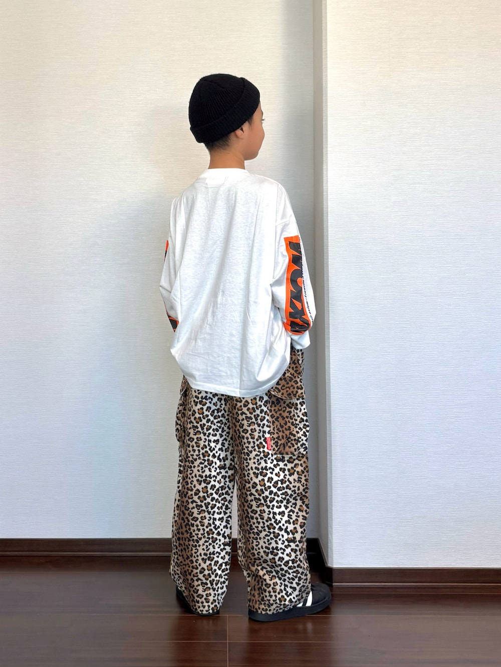 ブラック系のスニーカー、ホワイト系のTシャツ/カットソー、ブラウン系のカーゴパンツを着用したキッズの秋コーディネートの3枚目の写真
