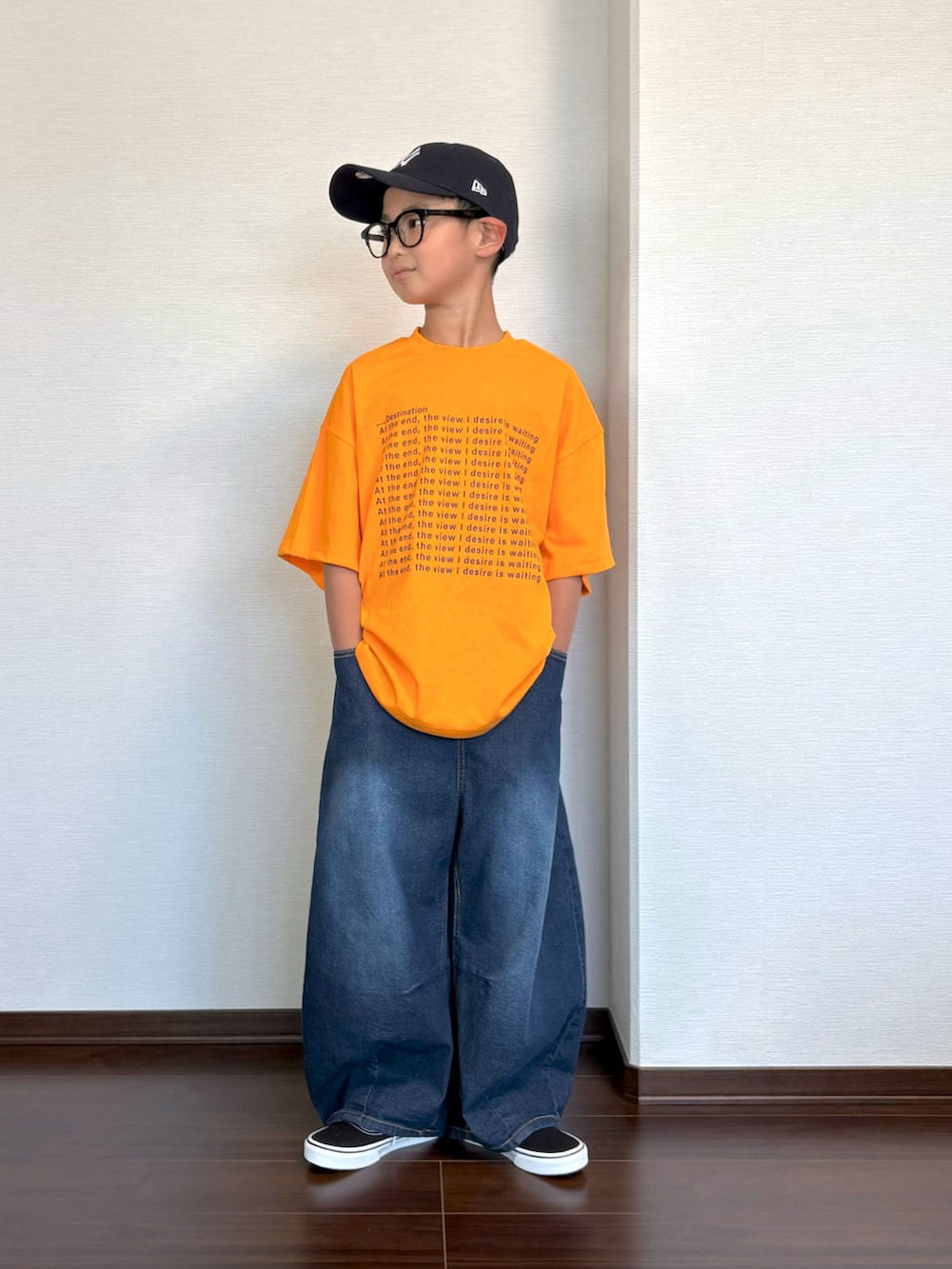 オレンジ系のTシャツ/カットソー、ブルー系のデニムパンツ、ブラック系のスニーカーを着用したキッズの夏コーディネートの2枚目の写真