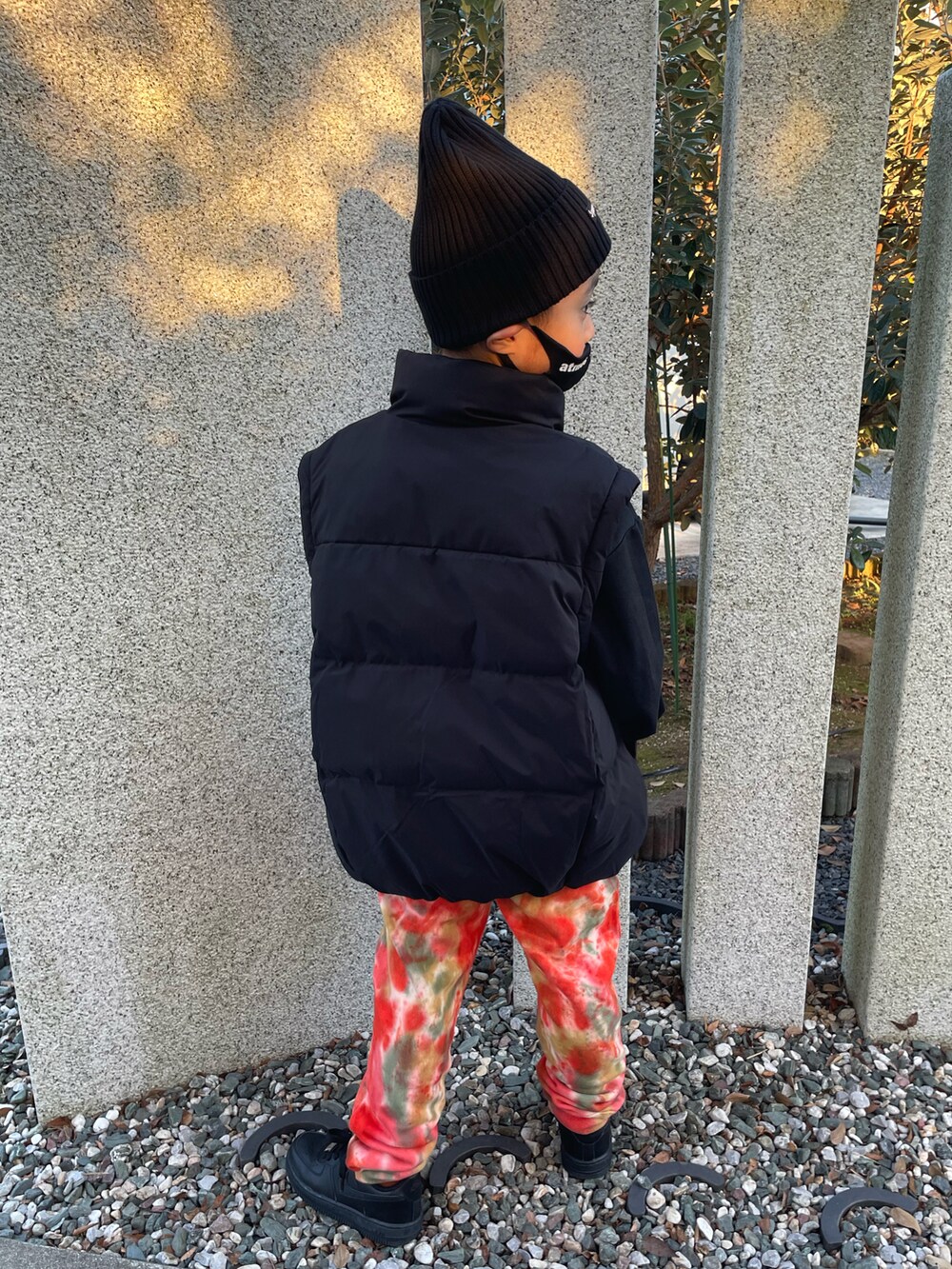ブラック系のスニーカー、オレンジ系のスウェットパンツ、ブラック系のダウンジャケット/コートを着用したキッズの秋コーディネートの2枚目の写真