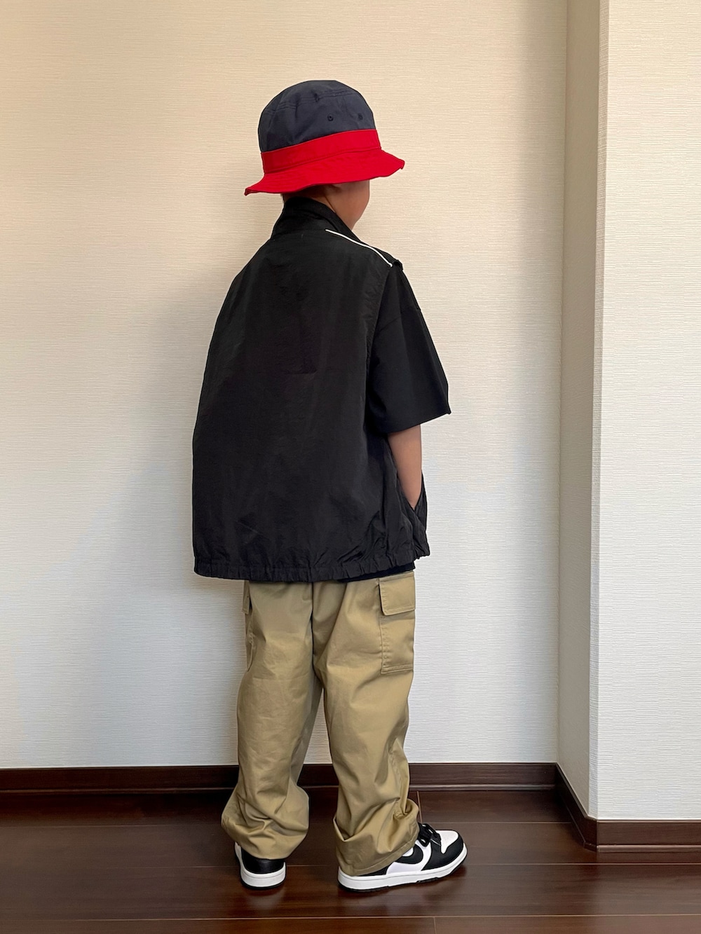 ブラック系のベスト、ブラック系のTシャツ/カットソー、ベージュ系のカーゴパンツを着用したキッズの春コーディネートの3枚目の写真