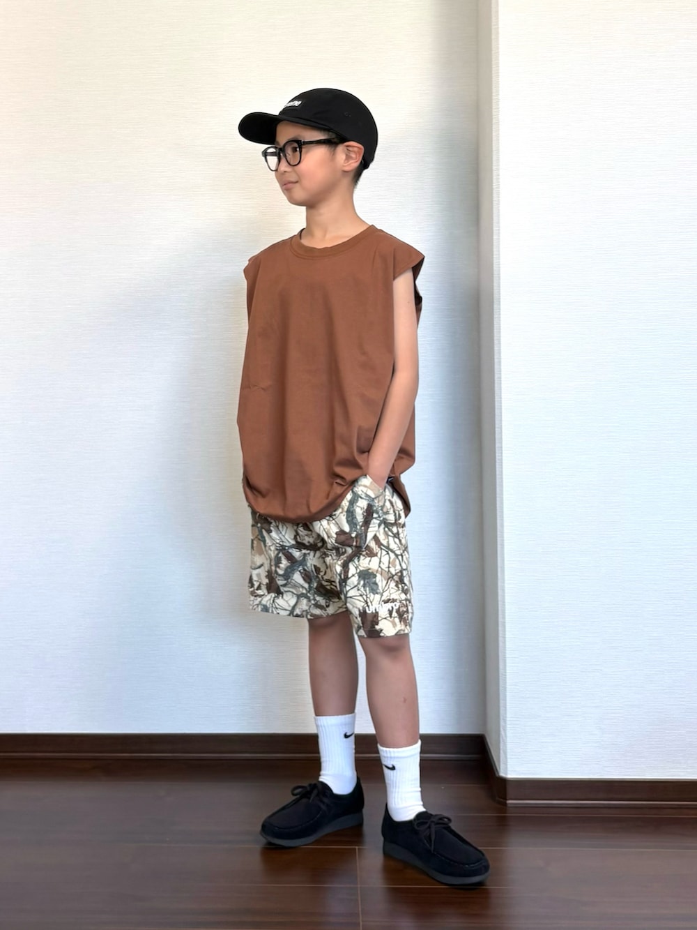 ブラウン系のタンクトップ、ベージュ系のパンツ、ブラック系のシューズを着用したキッズの夏コーディネートの2枚目の写真