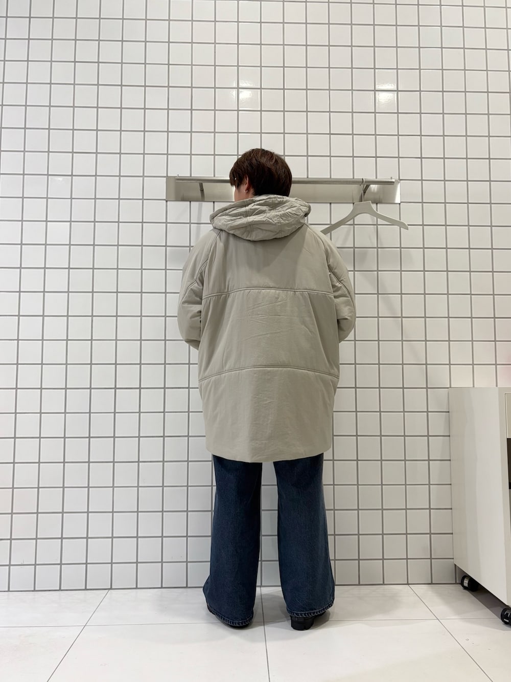 グレー系のスウェット、ブルー系のデニムパンツ、ベージュ系のダウンジャケット/コートを着用したメンズの秋コーディネートの6枚目の写真