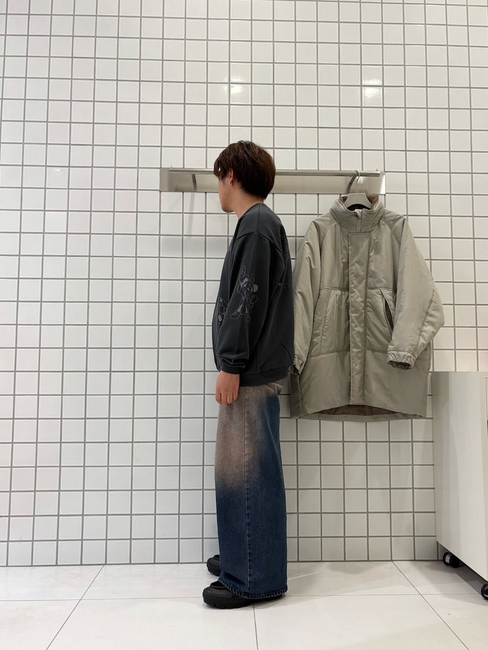 グレー系のスウェット、ブルー系のデニムパンツ、ベージュ系のダウンジャケット/コートを着用したメンズの秋コーディネートの2枚目の写真