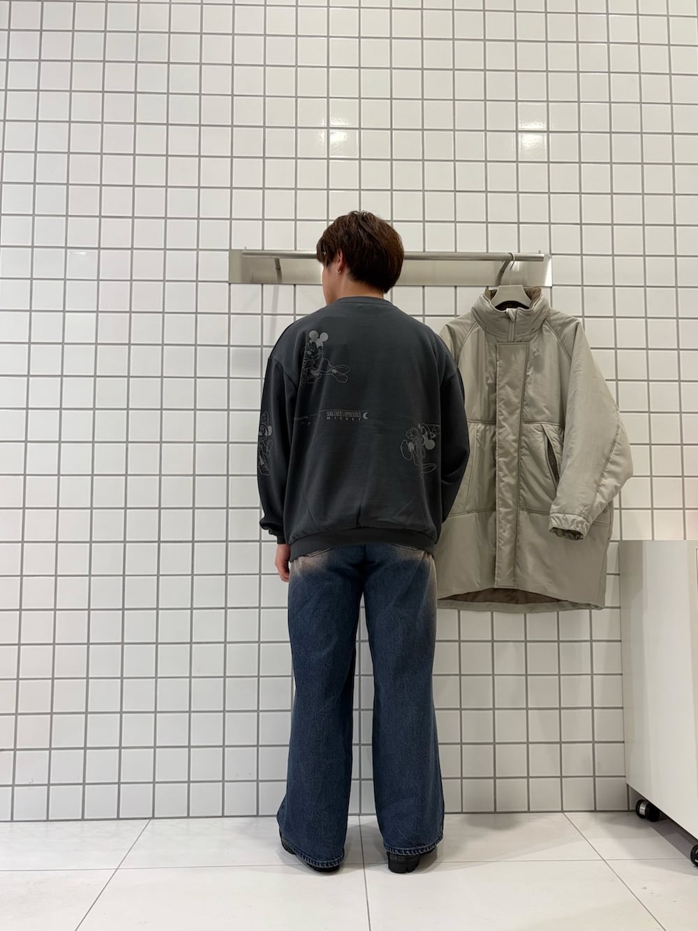 グレー系のスウェット、ブルー系のデニムパンツ、ベージュ系のダウンジャケット/コートを着用したメンズの秋コーディネートの3枚目の写真