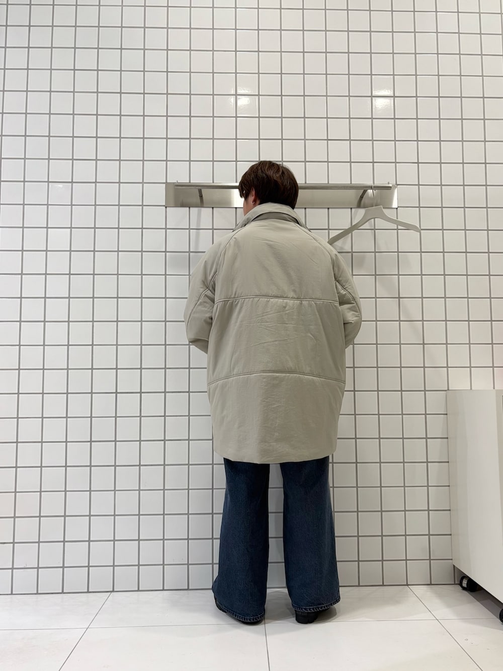 グレー系のスウェット、ブルー系のデニムパンツ、ベージュ系のダウンジャケット/コートを着用したメンズの秋コーディネートの5枚目の写真