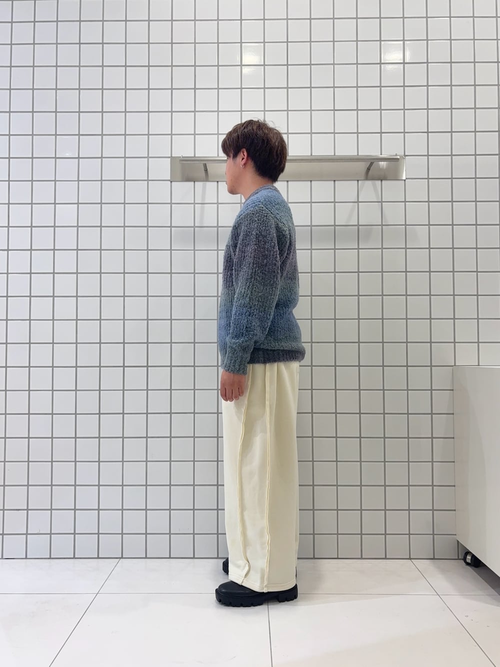 ブラック系のブーツ、ホワイト系のその他パンツ、ブルー系のニット/セーターを着用したメンズの秋コーディネートの2枚目の写真