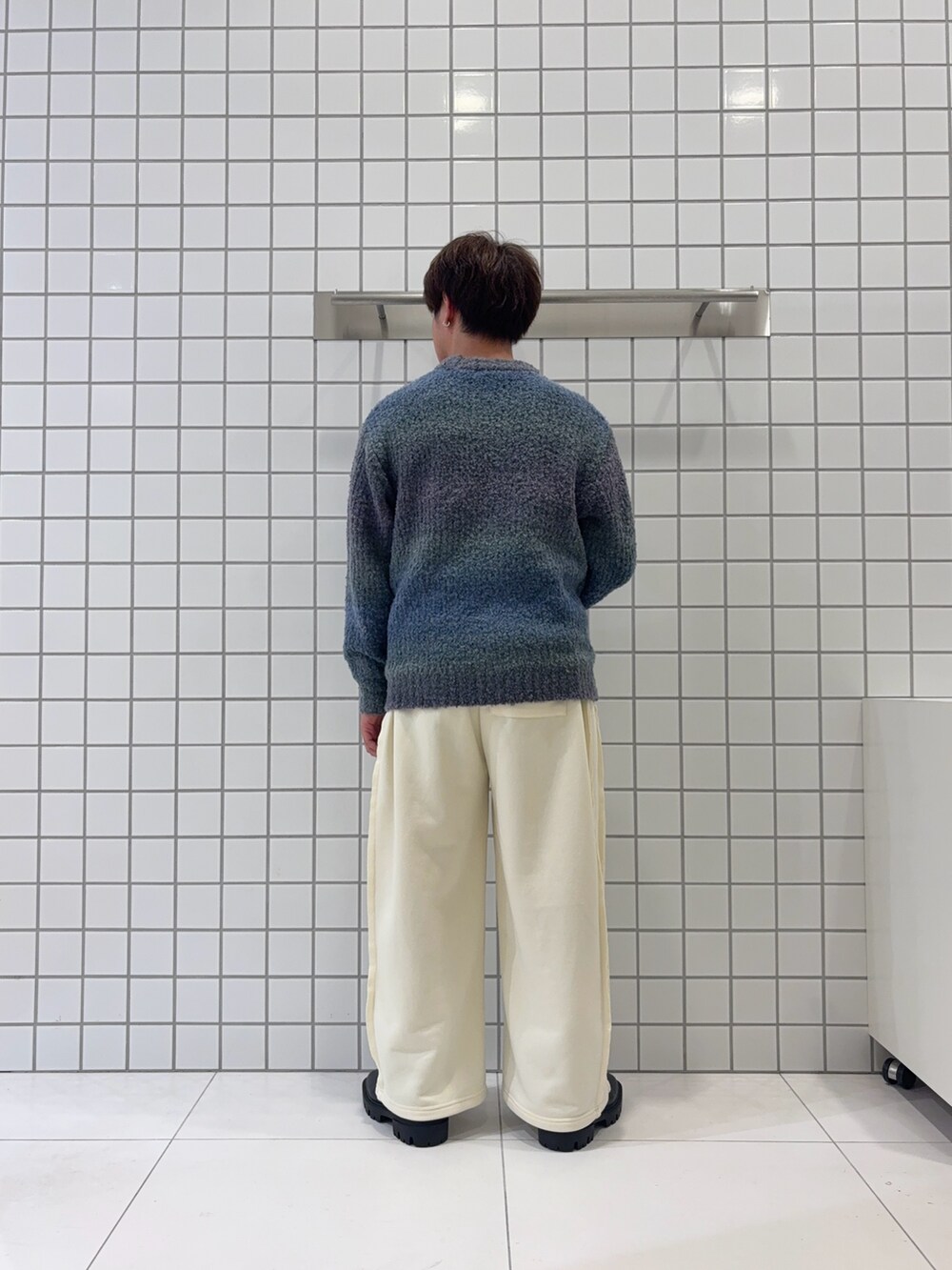 ブラック系のブーツ、ホワイト系のその他パンツ、ブルー系のニット/セーターを着用したメンズの秋コーディネートの3枚目の写真
