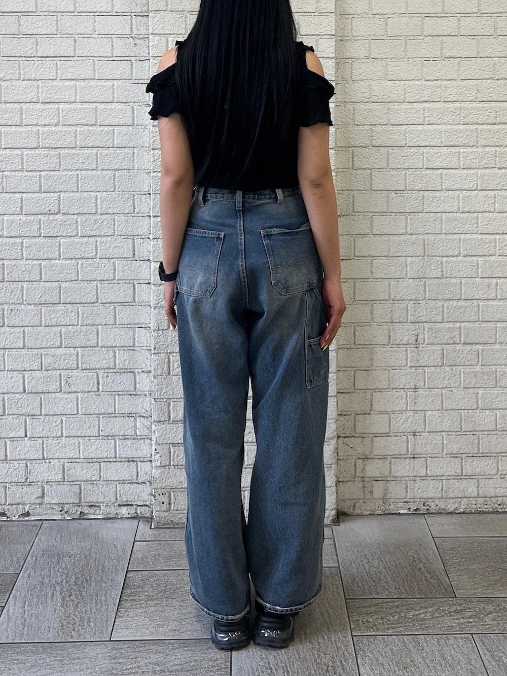 ブラック系のTシャツ/カットソー、ブラック系のニット/セーター、ブルー系のデニムパンツを着用したレディースの夏コーディネートの2枚目の写真