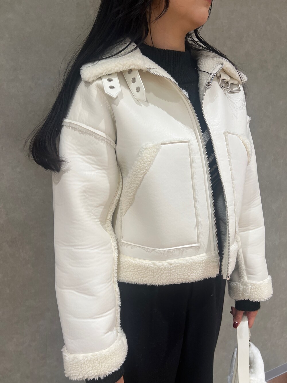 ホワイト系のブルゾン、ブラック系のその他パンツ、ブラック系のブーツを着用したレディースの冬コーディネートの3枚目の写真