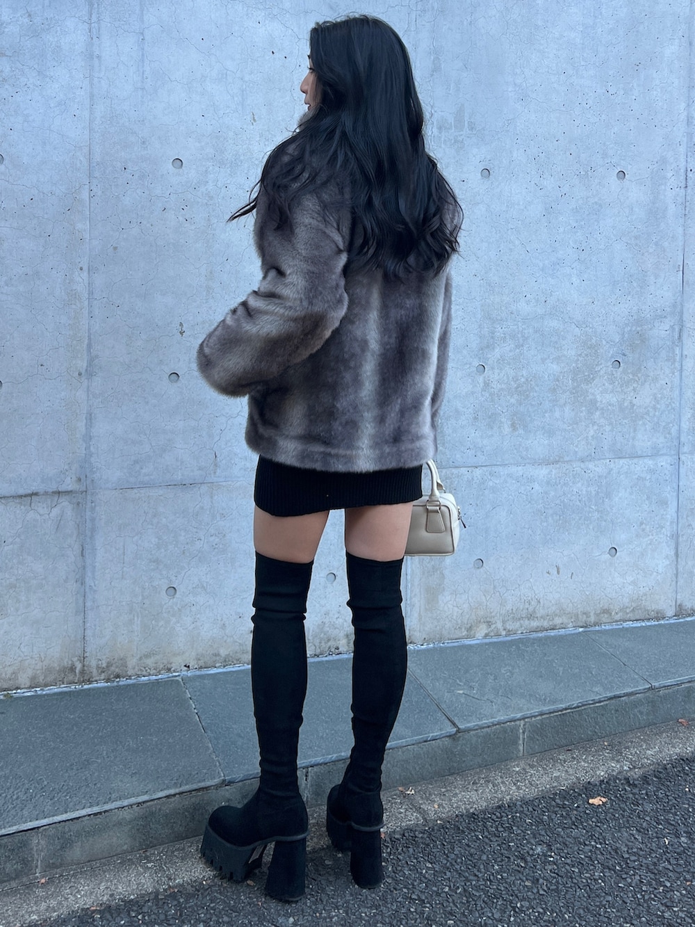 グレー系のその他アウター、ブラック系のワンピース、ブラック系のブーツを着用したレディースの冬コーディネートの3枚目の写真