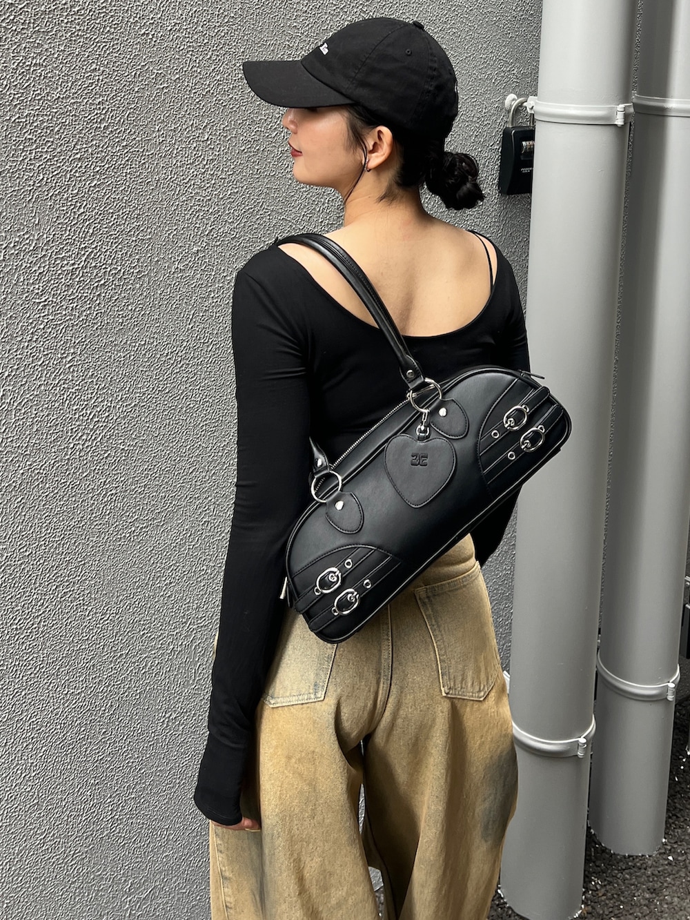 ベージュ系のデニムパンツ、ブラック系のブーツ、ブラック系のハンドバッグを着用したレディースの春コーディネートの4枚目の写真
