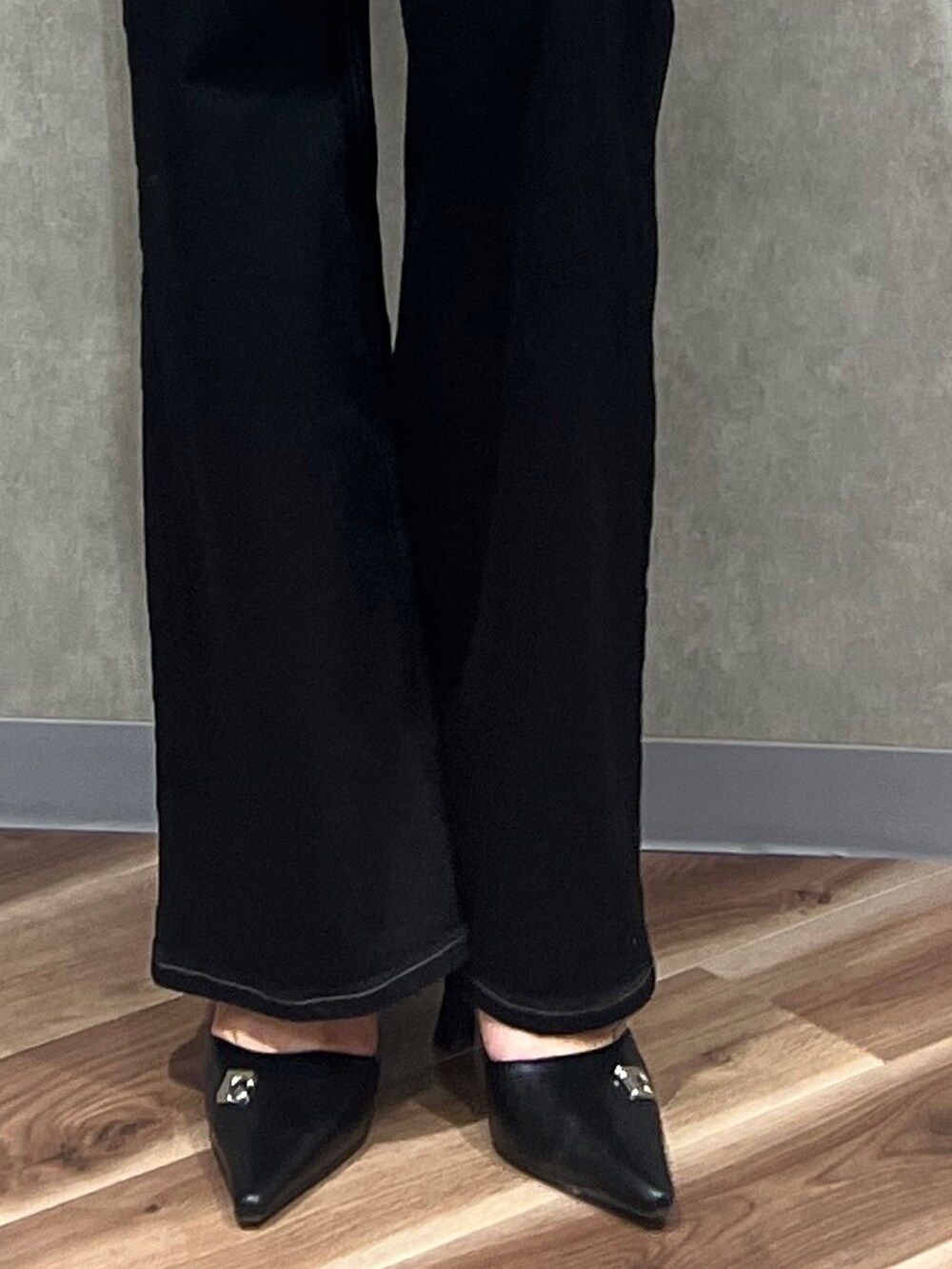 ブラック系のデニムパンツ、ブラック系のニット/セーター、ブラック系のパンプスを着用したレディースの春コーディネートの4枚目の写真