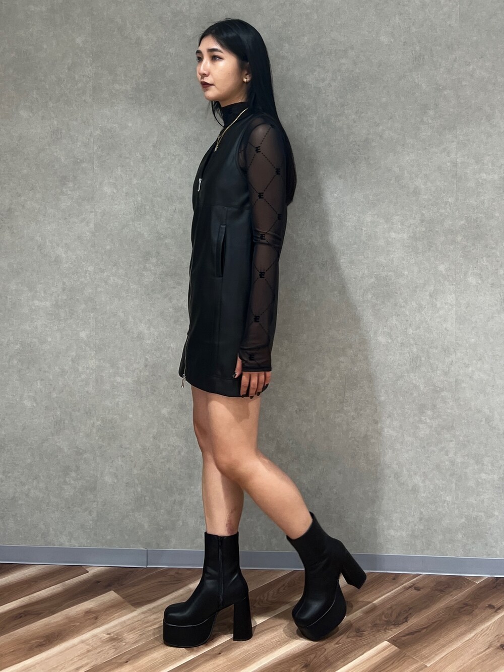 ブラック系のワンピース、ブラック系のTシャツ/カットソー、ブラック系のブーツを着用したレディースの秋コーディネートの2枚目の写真