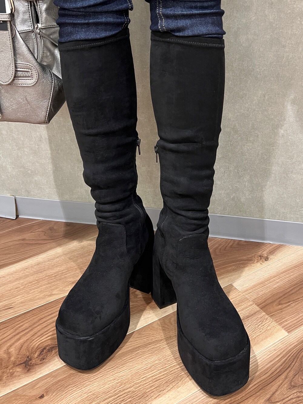 ブラック系のニット/セーター、ブルー系のデニムパンツ、その他のブーツを着用したレディースの秋コーディネートの6枚目の写真