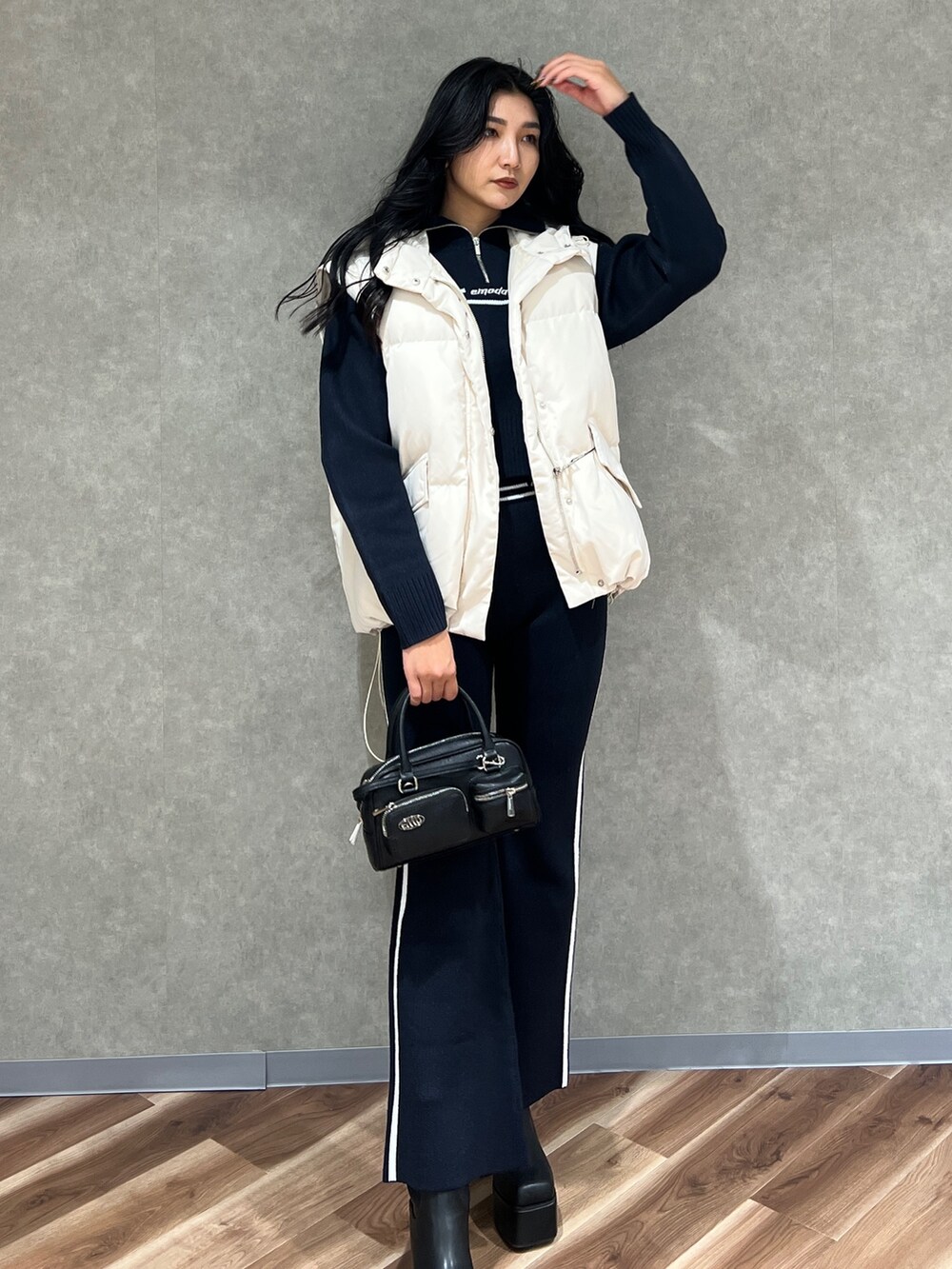 ホワイト系のブルゾン、ブラック系のニット/セーター、ブルー系のその他パンツを着用したレディースの秋コーディネートの2枚目の写真