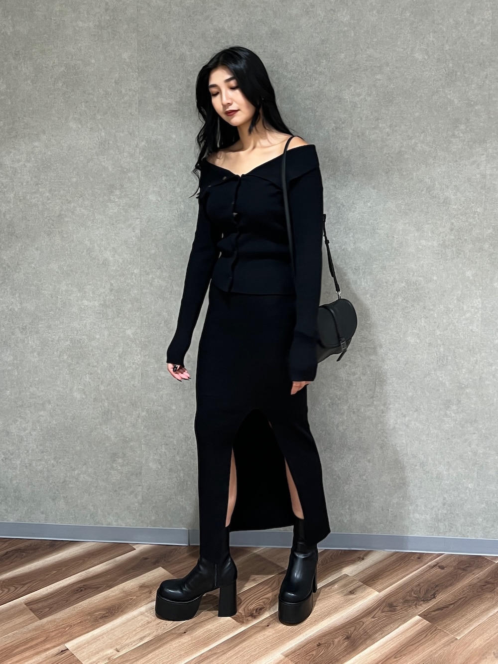 ブラック系のニット/セーター、ブラック系のスカート、ブラック系のブーツを着用したレディースの秋コーディネートの3枚目の写真