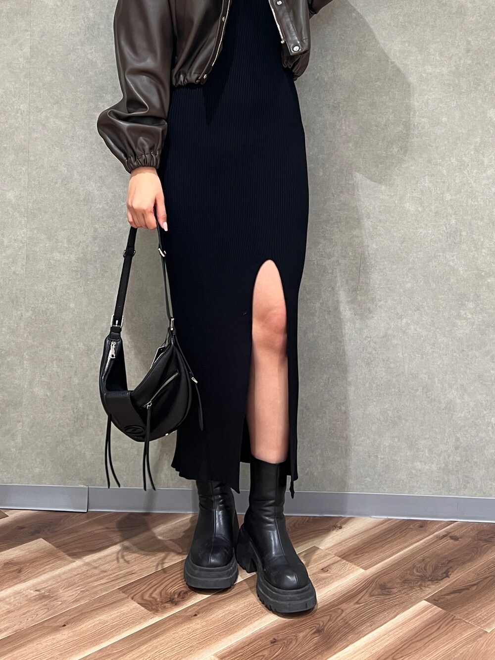 ブラウン系のブルゾン、ブラック系のワンピース、ブラック系のハンドバッグを着用したレディースの冬コーディネートの5枚目の写真