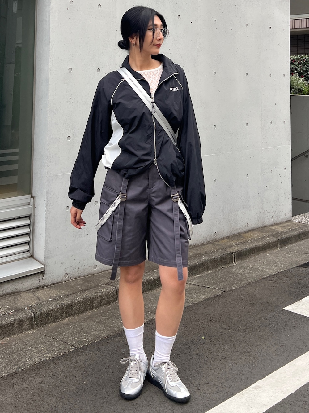 ブラック系のブルゾン、ホワイト系のTシャツ/カットソー、シルバー系のスニーカーを着用したレディースの春コーディネートの2枚目の写真