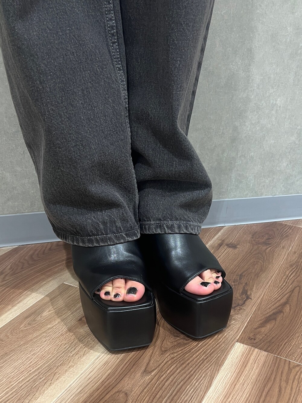 グレー系のニット/セーター、グレー系のデニムパンツ、ブラック系のサンダルを着用したレディースの春コーディネートの6枚目の写真
